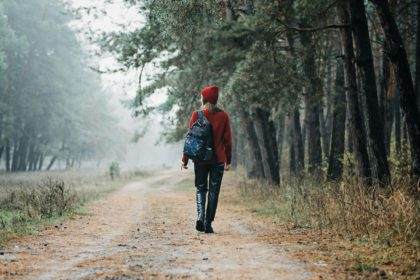 Weekend breaks and getaways in forests. Stay close to nature. Young woman in red hat