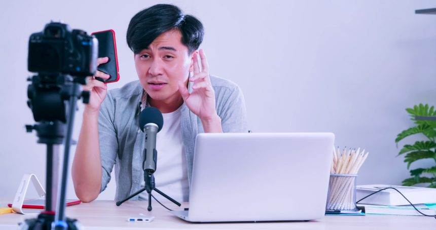 Young asian man selling digital gadgets on social media by streaming live from his home.